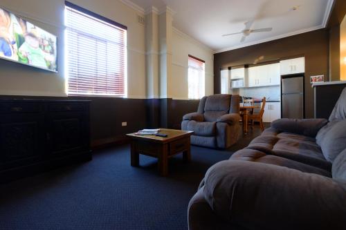 una sala de estar con un sofá y una mesa en Kyogle Commercial Hotel, en Kyogle