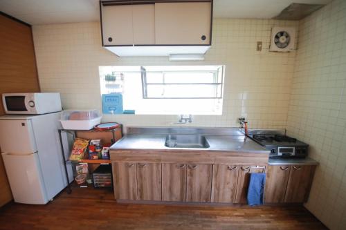 a small kitchen with a sink and a refrigerator at ulala hometown - Vacation STAY 09297v in Kagoshima