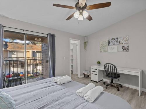 - une chambre avec un lit, un bureau et un ventilateur de plafond dans l'établissement Sleek condo explore on wheels, à Gainesville