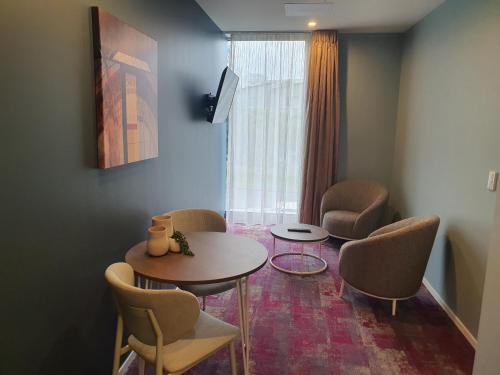 a room with a table and chairs and a window at La Quinta by Wyndham Parnell Auckland in Auckland