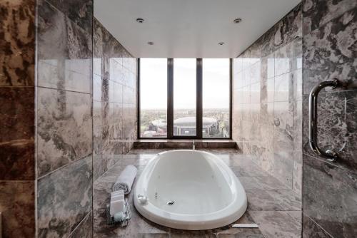 a bathroom with a tub and a large window at InterContinental Adelaide, an IHG Hotel in Adelaide