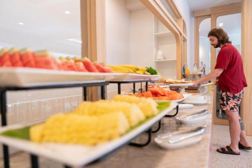 a man standing in front of a buffet of food at The Verandah - SHA Extra Plus in Ao Nang Beach