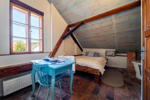 a bedroom with a bed and a blue table at Art Gallery Dyk in Chvalšiny