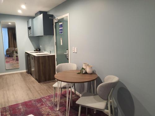 a kitchen with a table and chairs in a room at La Quinta by Wyndham Parnell Auckland in Auckland