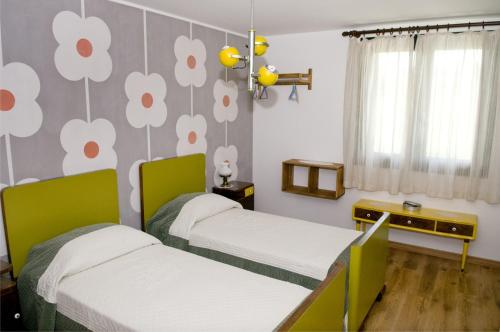 2 camas en una habitación con flores en la pared en Agriturismo Scribano, en Prepotto