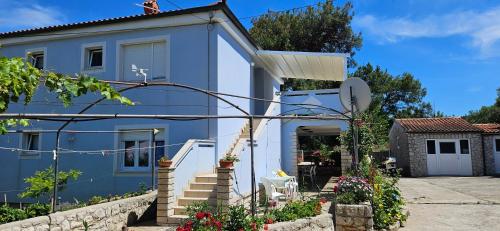 a blue and white house with stairs and flowers at Kuća Luce in Mali Lošinj