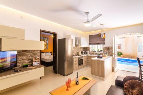 a large kitchen and living room with a refrigerator at Maisonnette & Pool Ta'Cenc Sannat Gozo - Happy Rentals in Sannat
