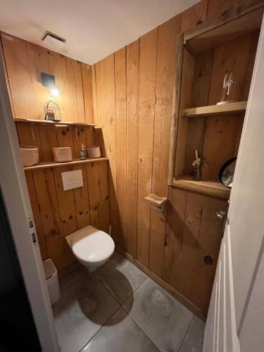 La salle de bains est pourvue de toilettes et de murs en bois. dans l'établissement Maison bois 6pers Biscarrosse, à Biscarrosse