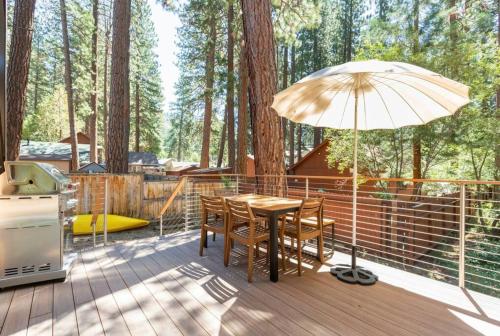 a wooden deck with a table and an umbrella at Brand New Modern A-Frame In Kings Beach Two Blocks From The Beach in Kings Beach
