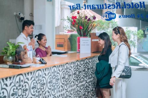 a group of people standing around a counter at Home Chic Hotel in Phnom Penh