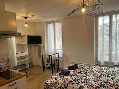 une chambre avec un lit et une cuisine avec une table dans l'établissement Appartement de charme dans le residence historique du Grand hotel, à Aix-les-Bains