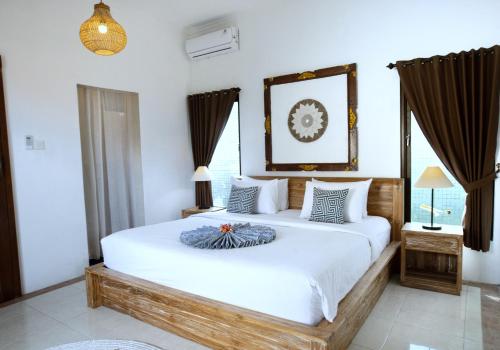 Un dormitorio con una gran cama blanca y ventanas. en Tattva Uluwatu, Surf & Yoga Retreat, en Jimbaran