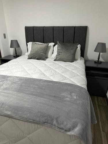 a bedroom with a large bed with two end tables at home 333 habitacion 337 in Escazu