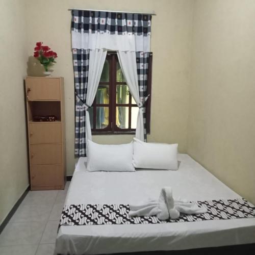 Ένα ή περισσότερα κρεβάτια σε δωμάτιο στο Homestay Bu Enik Borobudur by BToC