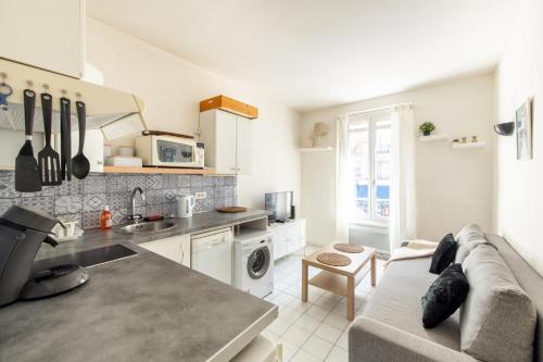 une cuisine et un salon avec un canapé dans l'établissement 1 Bedroom apartment ideally located only 1 minute to the metro in Montmartre neighbourhood, à Paris
