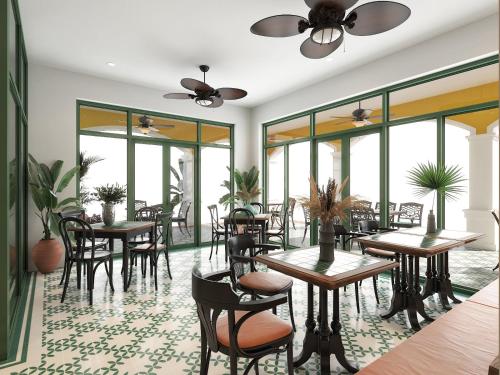 a restaurant with tables and chairs and windows at Plum Village Moc Chau in Mộc Châu
