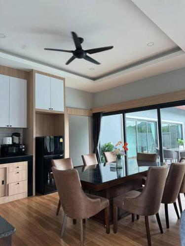 a kitchen with a table and chairs and a ceiling fan at Sun Ray Private Pool villa 3 bed in Ao Nang
