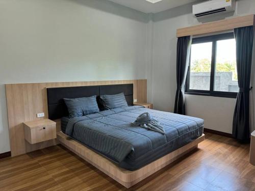 a bedroom with a bed with a blue comforter and a window at Sun Ray Private Pool villa 3 bed in Ao Nang 