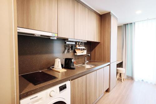 a kitchen with a sink and a stove at Elmomento Haeundae in Busan