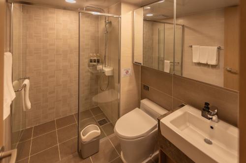 a bathroom with a toilet and a sink and a shower at Elmomento Haeundae in Busan