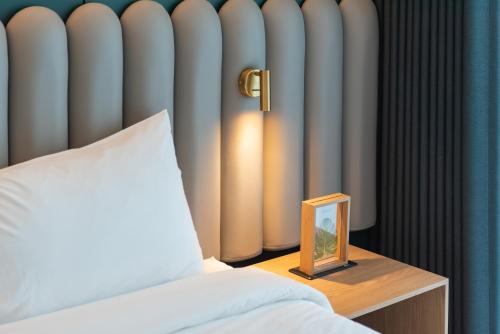a bedroom with a bed and a table with a mirror at Elmomento Haeundae in Busan