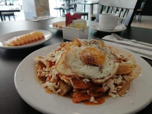 a plate of food with an egg on top of pasta at Hotel & Lounge Las Islas in San Juan Bautista Tuxtepec