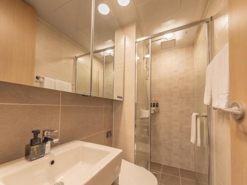 a bathroom with a white sink and a shower at Elmomento Haeundae in Busan