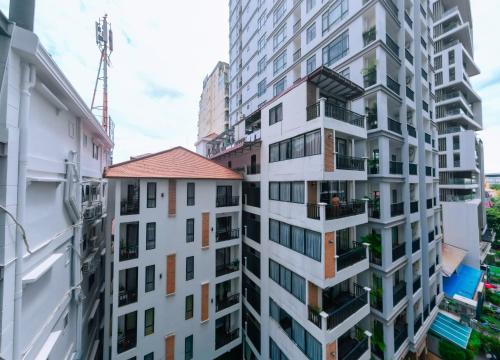 a tall white apartment building with balconies at Home Chic Hotel in Phnom Penh