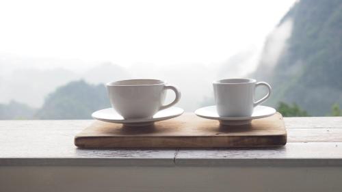 two coffee cups sitting on a wooden tray at ahpokafei อาโพดอยผาหมี in Ban Pha Mi