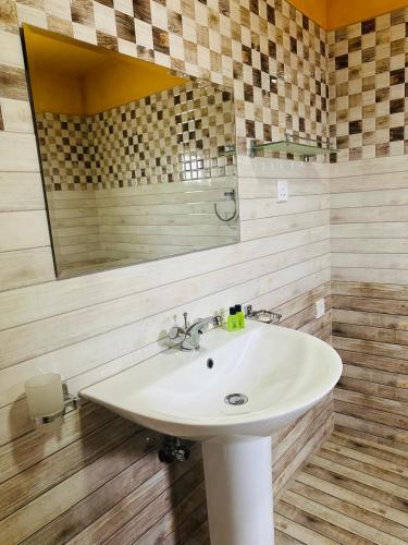 a bathroom with a sink and a mirror at Funwhales Rest House in Negombo
