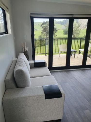 a living room with a couch and a balcony at Piece of Paradise in Auckland