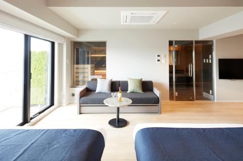 a living room with two beds and a couch at MONday Apart Premium Asakusa in Tokyo