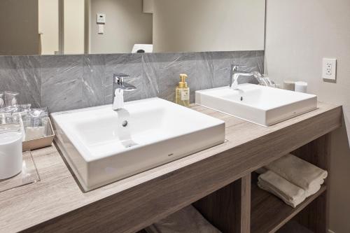 a bathroom with two white sinks on a counter at MONday Apart Premium Asakusa in Tokyo