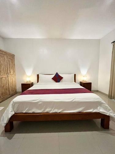a bedroom with a large bed with two lamps at Pererenan nengah guest house canggu in Canggu