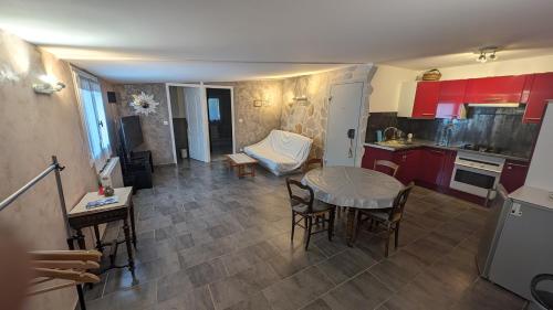 a kitchen with red cabinets and a table and chairs at Maisonnette de Villiers gare à 5 minutes in Saint-Fargeau-Ponthierry