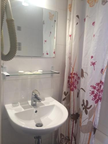 une salle de bain avec un lavabo et un miroir dans l'établissement Hotel Cluny Sorbonne, à Paris