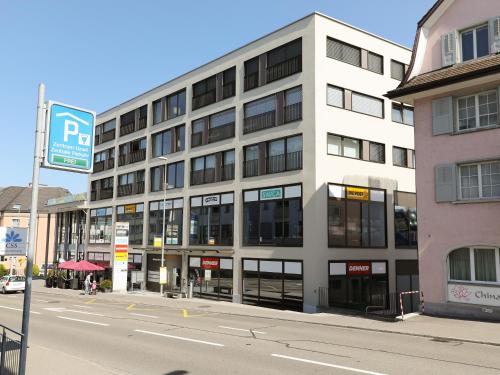 a large white building on a city street at Uze Apartments in Uzwil SG in Uzwil