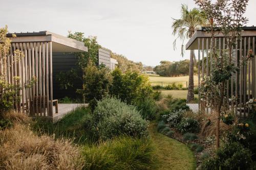 a garden with a wooden fence and plants at Bangalay Luxury Villas in Shoalhaven Heads