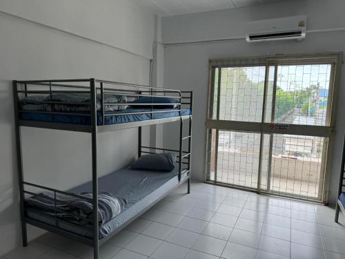 two bunk beds in a room with a window at JS786 Cafe&Bistro in Pattaya