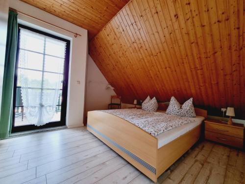 a bedroom with a bed and a large window at Pension & Wirtshaus ''Tun Eikkoter'' Eichkater in Wieck