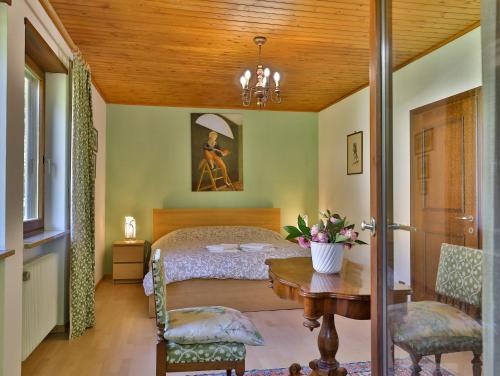 a bedroom with a bed and a table and chairs at Villa Atelier Baron Killi in Caldaro
