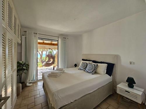 sypialnia z dużym białym łóżkiem i oknem w obiekcie Beachfront House 13 ,Glyfada w mieście Glifada