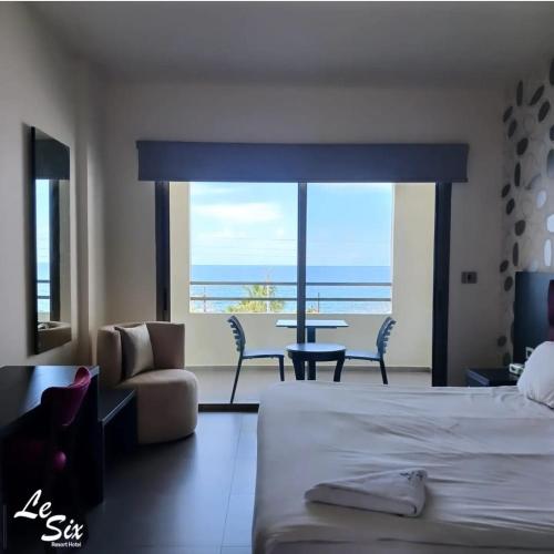 a bedroom with a bed and a view of the ocean at Le Six Hotel And Resort in Batroûn