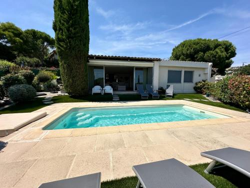 a swimming pool in the yard of a house at Villa MahJong Piscine Vue Mer Clim 6 adultes et 2 enfants in Cavalaire-sur-Mer