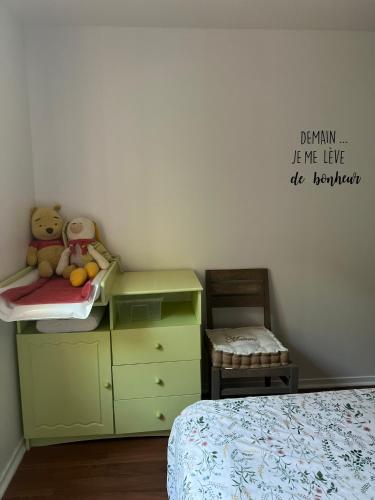 une chambre avec un lit et une commode avec un ours en peluche dessus dans l'établissement Gîte Le Crot de Villiers avec Bain Nordic, à Dornecy