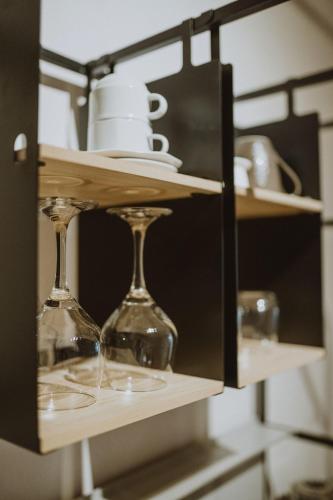 a shelf with wine glasses and plates on it at Garden House Apartments in Cēsis