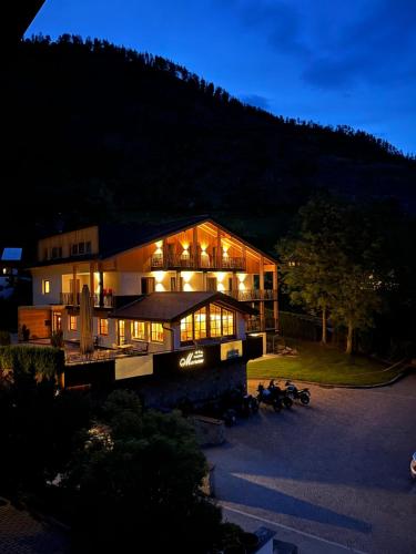 a large house with lights on in the night at Garni Marianne in Malles Venosta