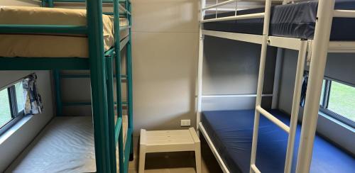 a small room with two bunk beds and a table at Camp Elim in Forster