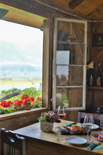 a table with two glasses of wine and a window at Arzenhof, Baron Di Pauli in Caldaro