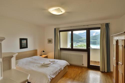 a bedroom with a bed and a large window at Arzenhof, Baron Di Pauli in Caldaro